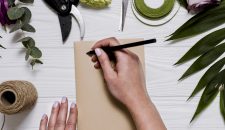 crop-hand-writing-table-with-florist-equipment