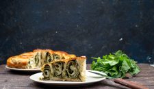 front-view-cooked-greens-pastry-inside-plates-with-fresh-greens-dark-surface
