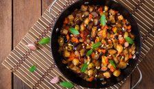 Italian Caponata with frying pan on a wooden background