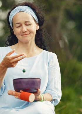 Senior woman with hindu things. Lady in a blue dress. Brunette sitting.