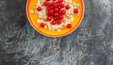 top-close-up-view-berries-plate-appetizing-red-currants-grey-table